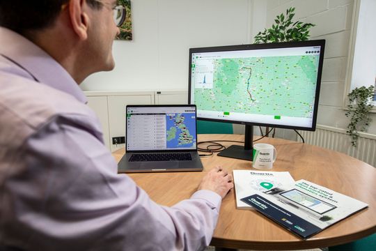 A man is sitting at a table with a laptop and a computer.