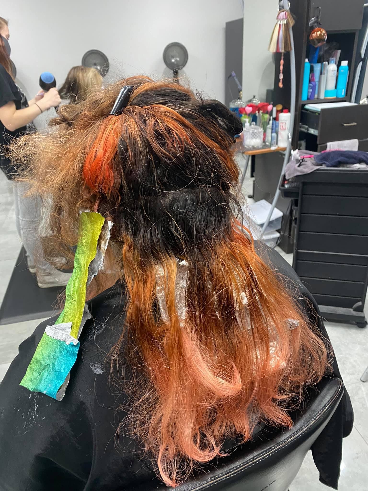 A woman is getting her hair dyed in a salon.