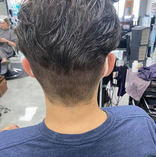 A man is getting his hair cut at a barber shop