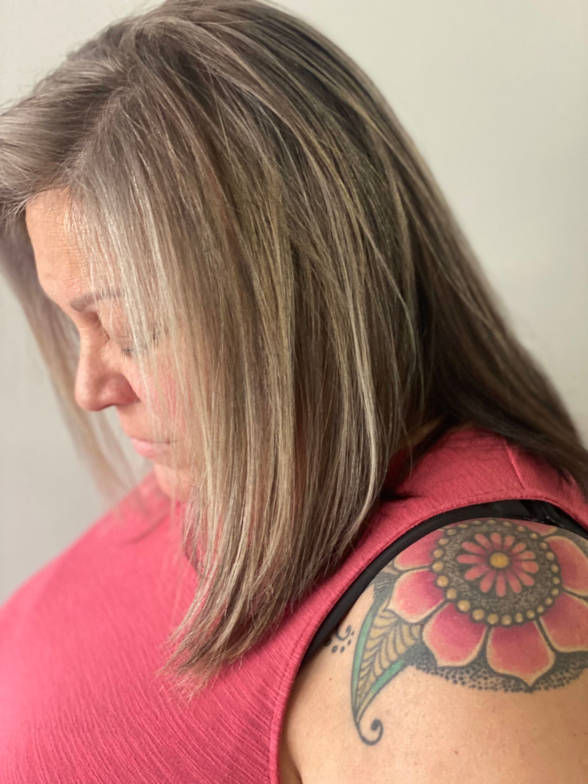 A woman with long hair and a tattoo on her shoulder.