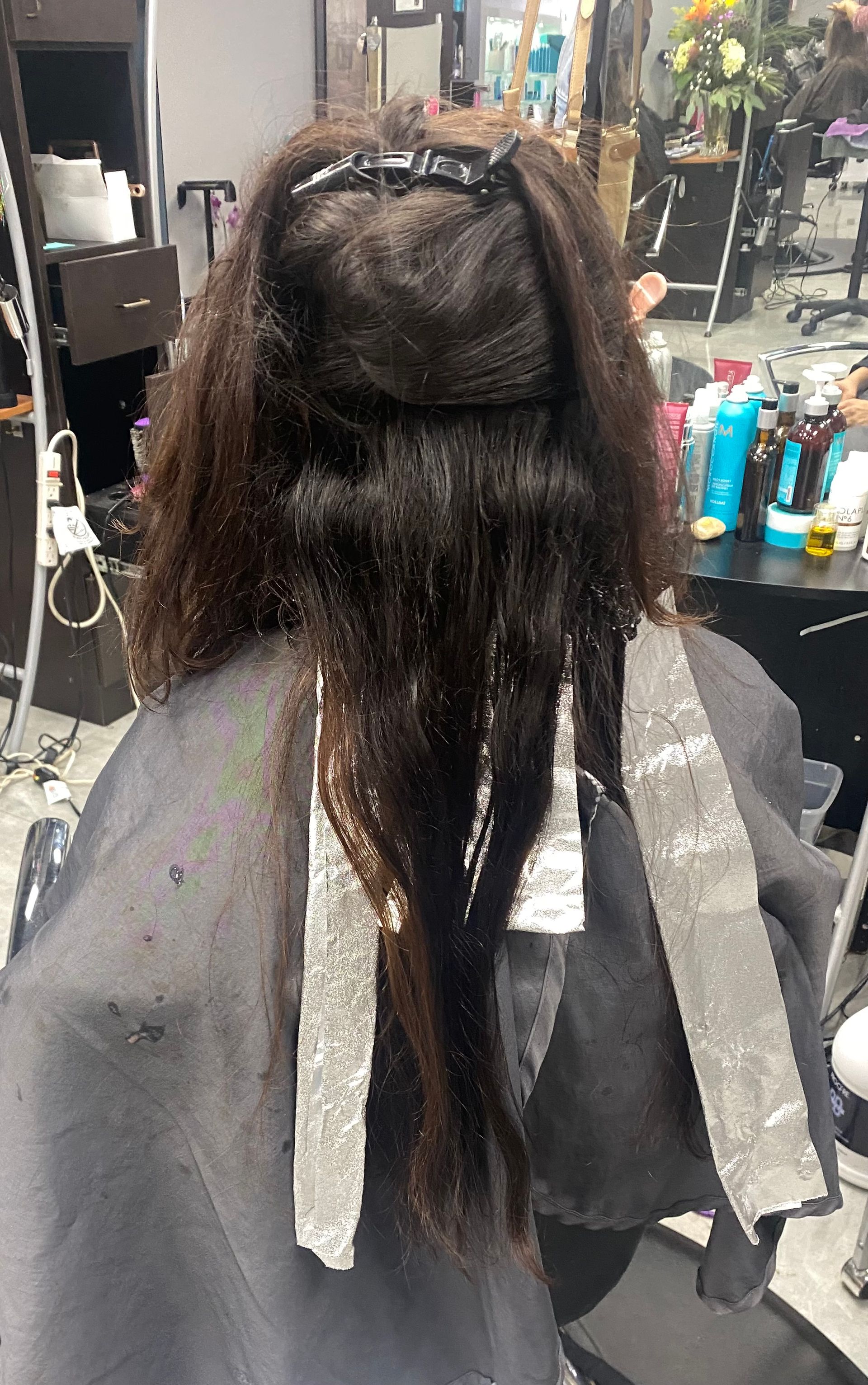 A woman is getting her hair dyed in a salon.