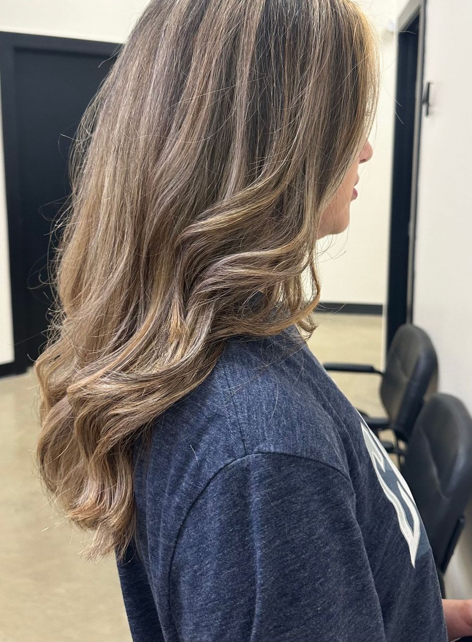 A woman with long brown hair is wearing a blue shirt.