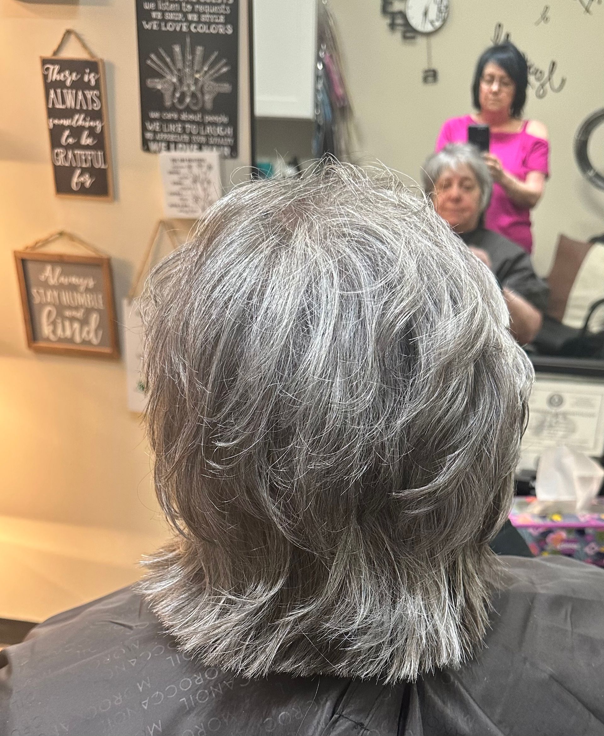 A woman is getting her hair dyed in a salon.