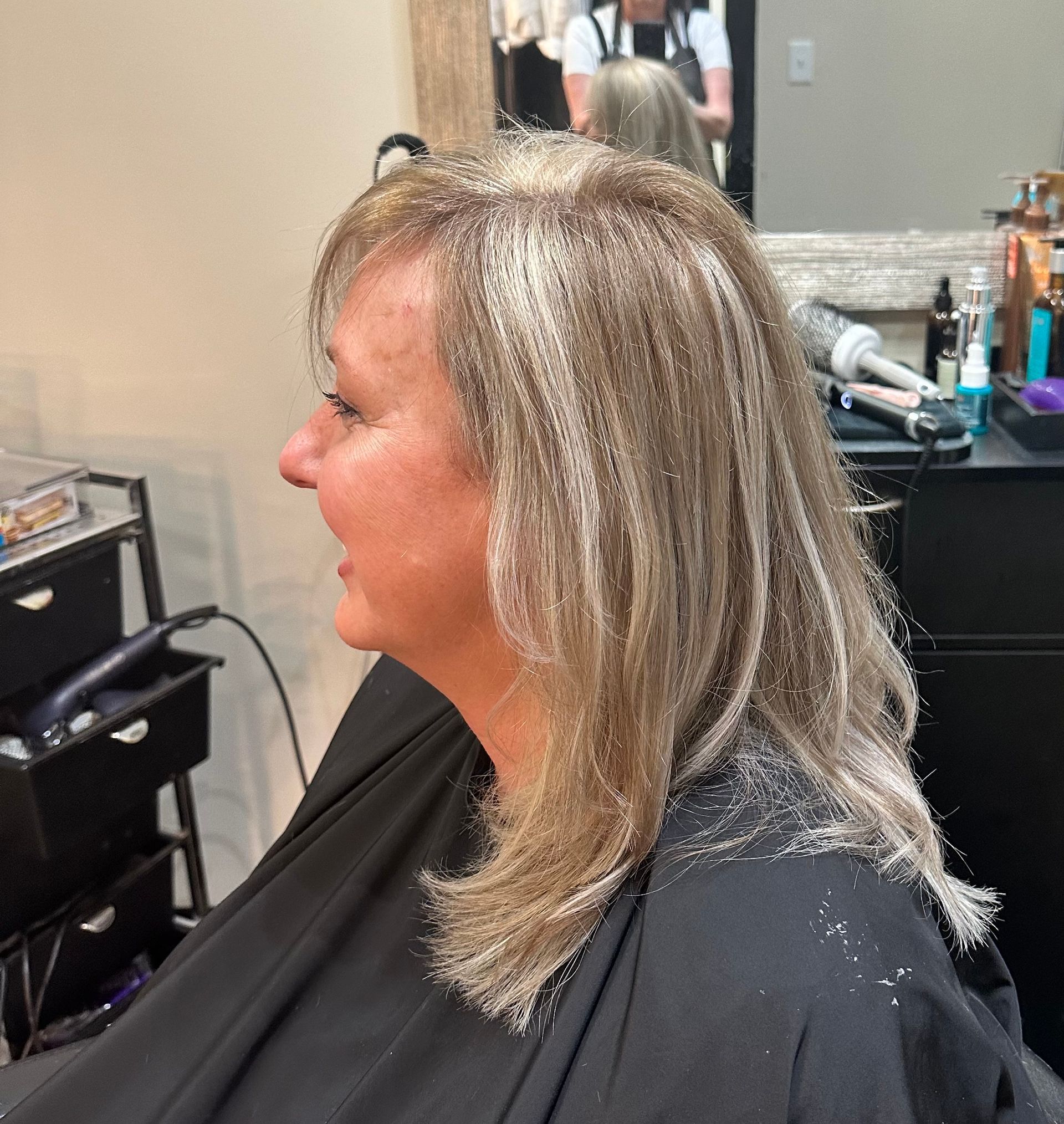 A woman is getting her hair cut in a salon
