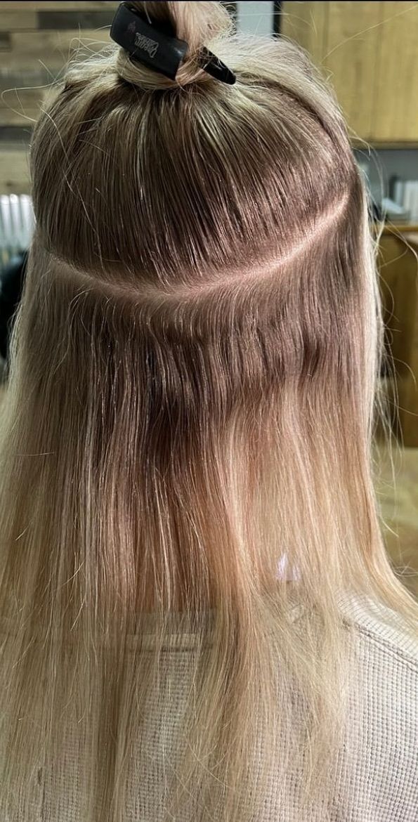 A woman is getting her hair done by a hairdresser.