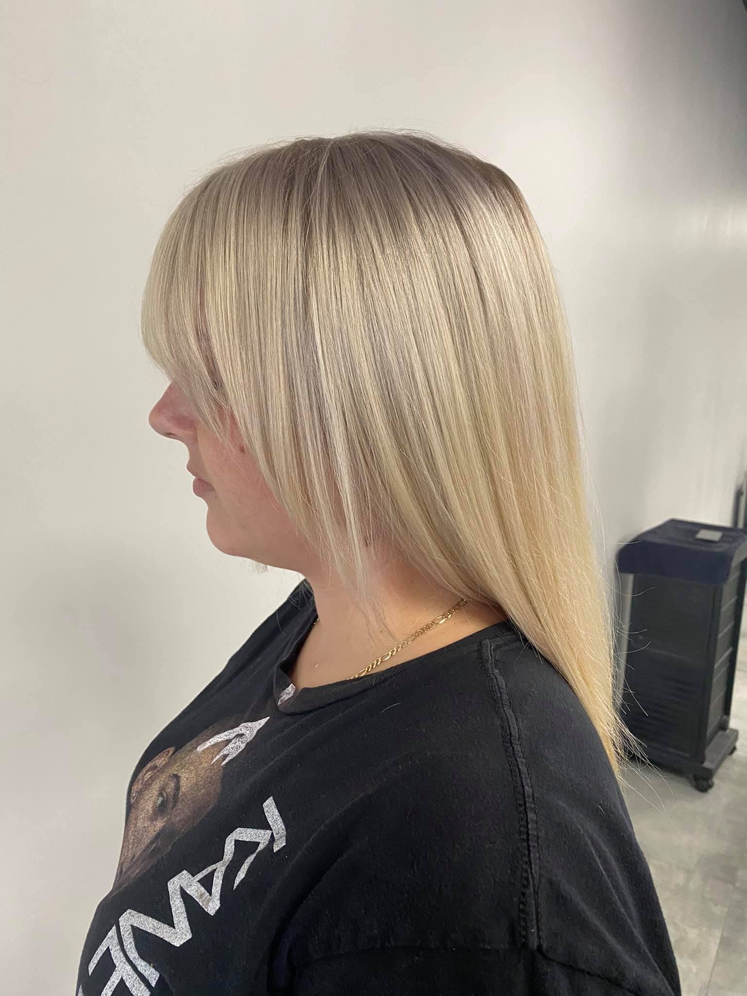 A woman with long blonde hair is wearing a black shirt.