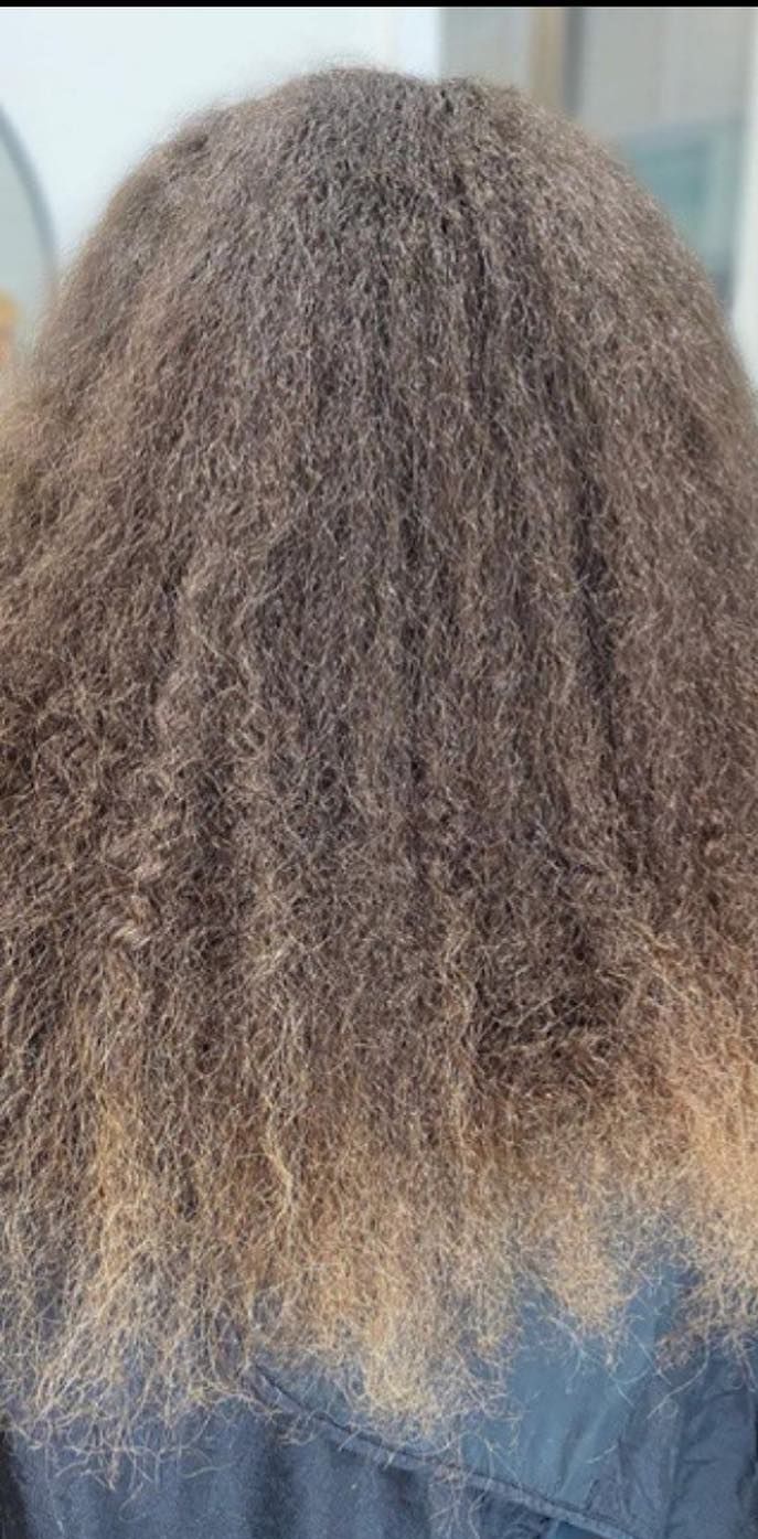 A close up of a person 's hair with a blue shirt on.