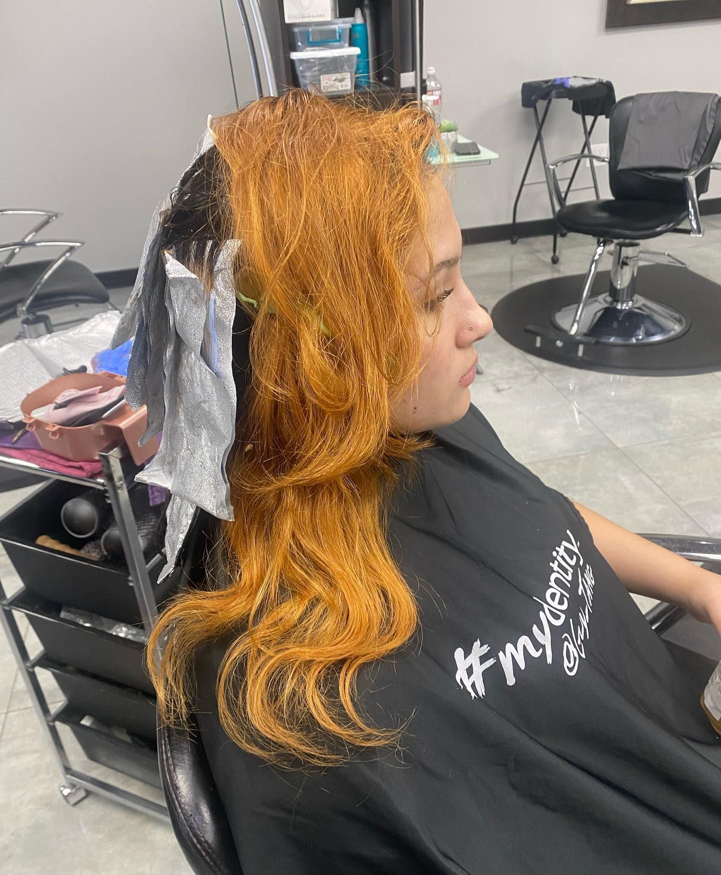 A woman is getting her hair dyed in a salon.