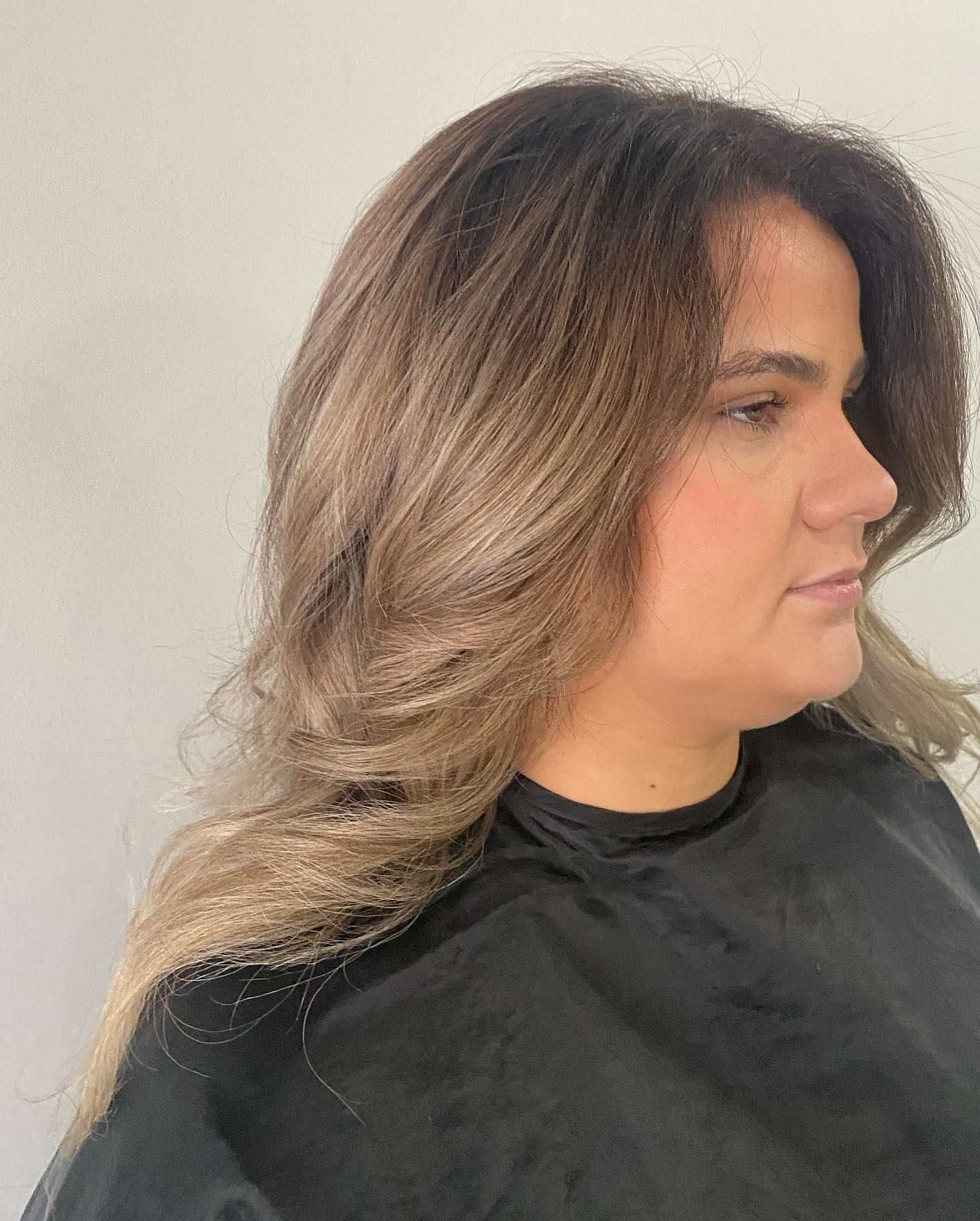 A woman with long hair is wearing a black cape.