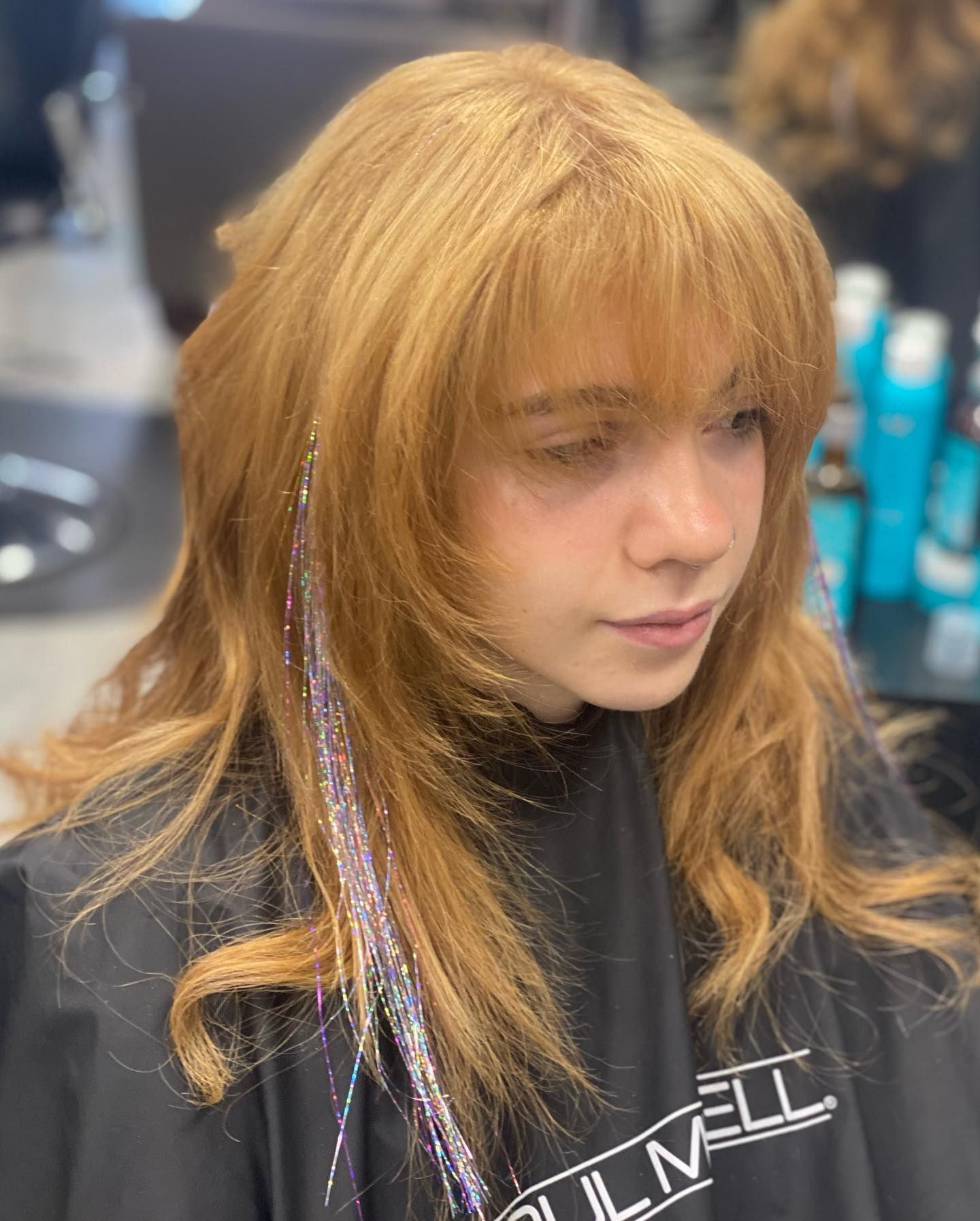 A woman is getting her hair cut in a salon.