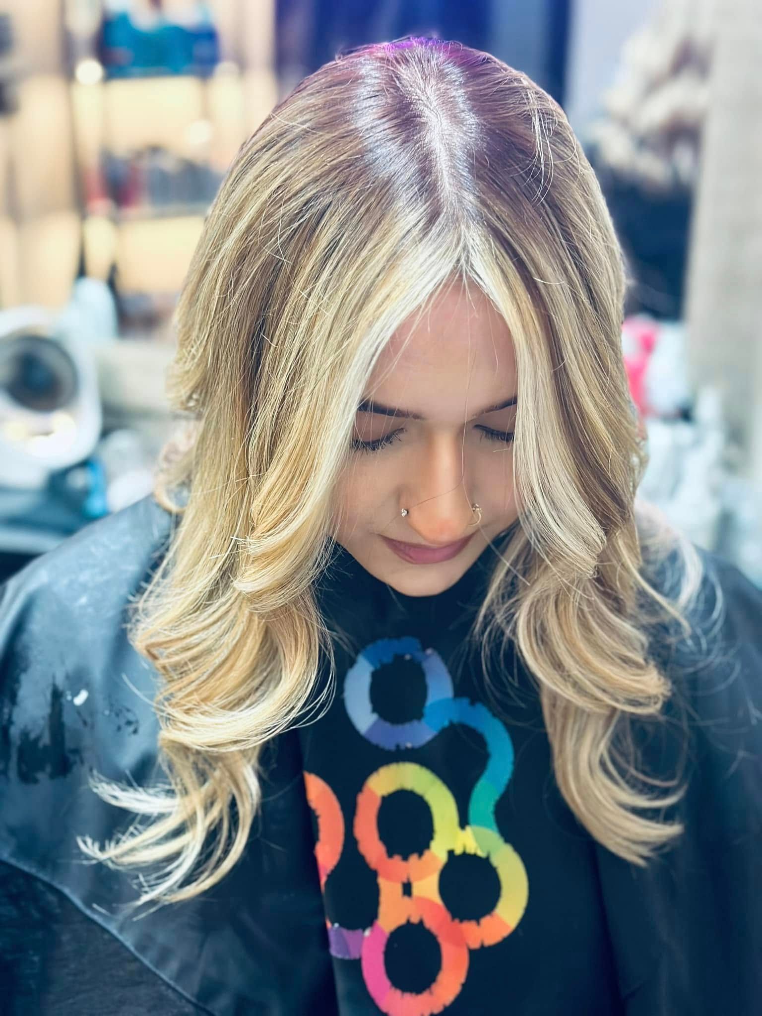 A woman is getting her hair cut at a salon.