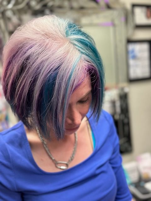 A woman with blonde hair is sitting in a chair with her eyes closed.