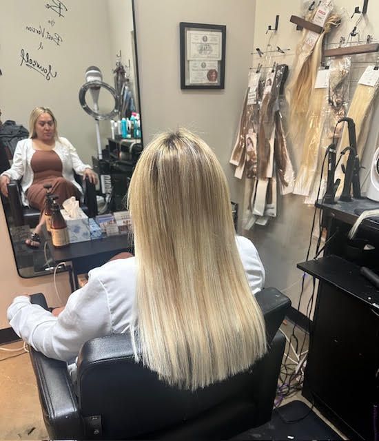 A woman with blonde hair is sitting in a chair in a salon