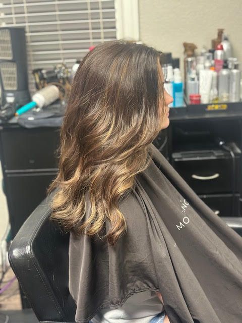 A woman is getting her hair cut in a salon.
