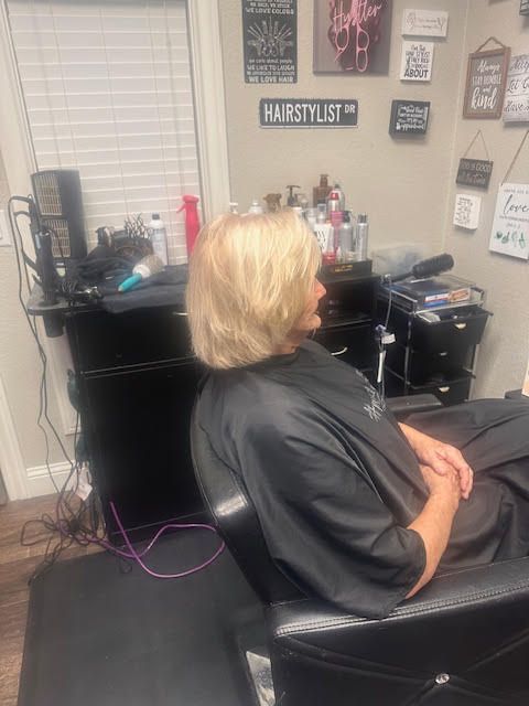 A man is getting his hair cut at a barber shop