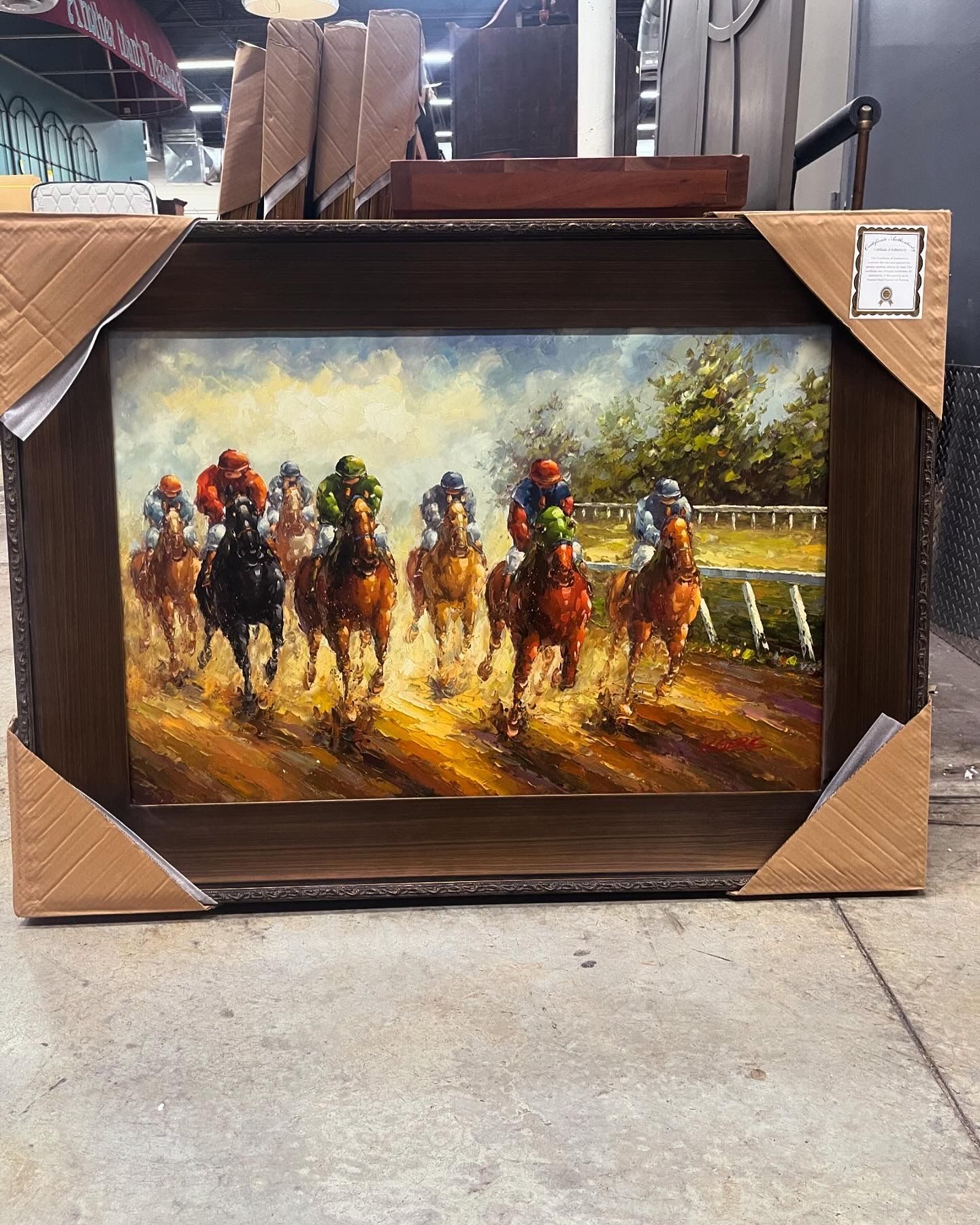 An oil painting of a horse race, featuring multiple jockeys in colorful silks galloping on a track toward the viewer.