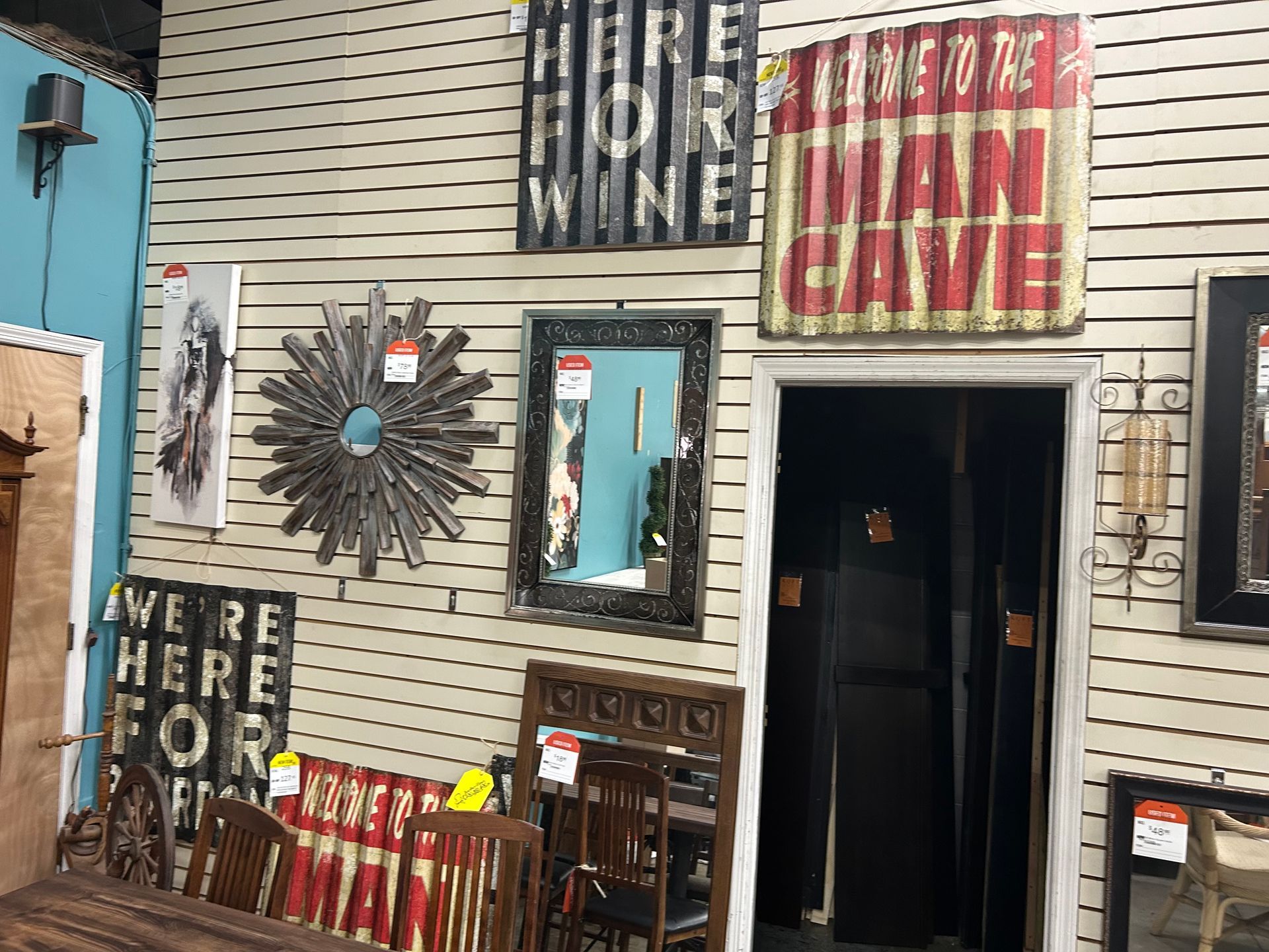 A wall displays various home decor items for sale, including a