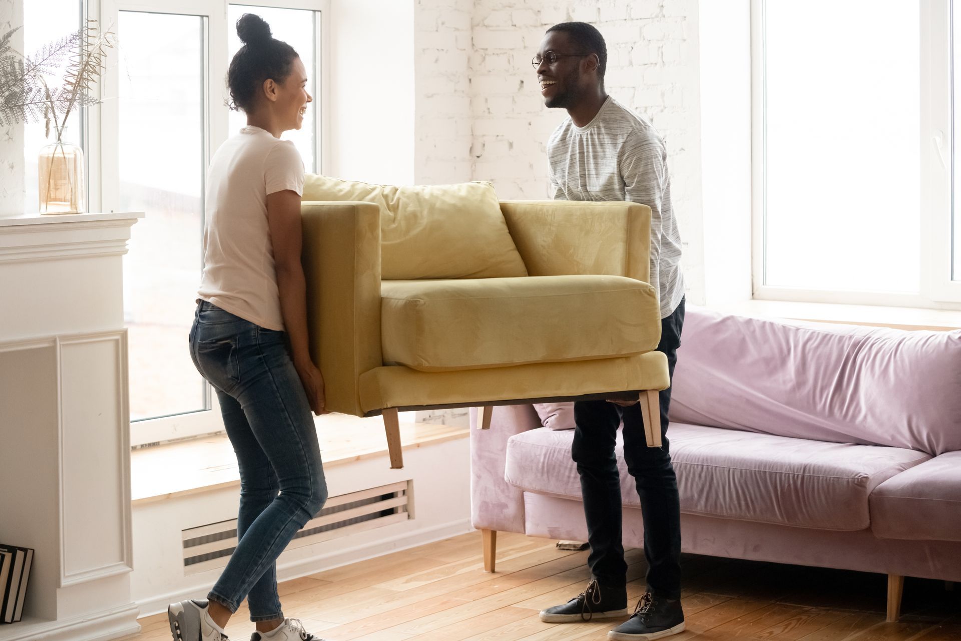 A Couple Moving a New Accent Chair into Their Apartment