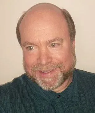 A bald man with a beard is smiling for the camera.