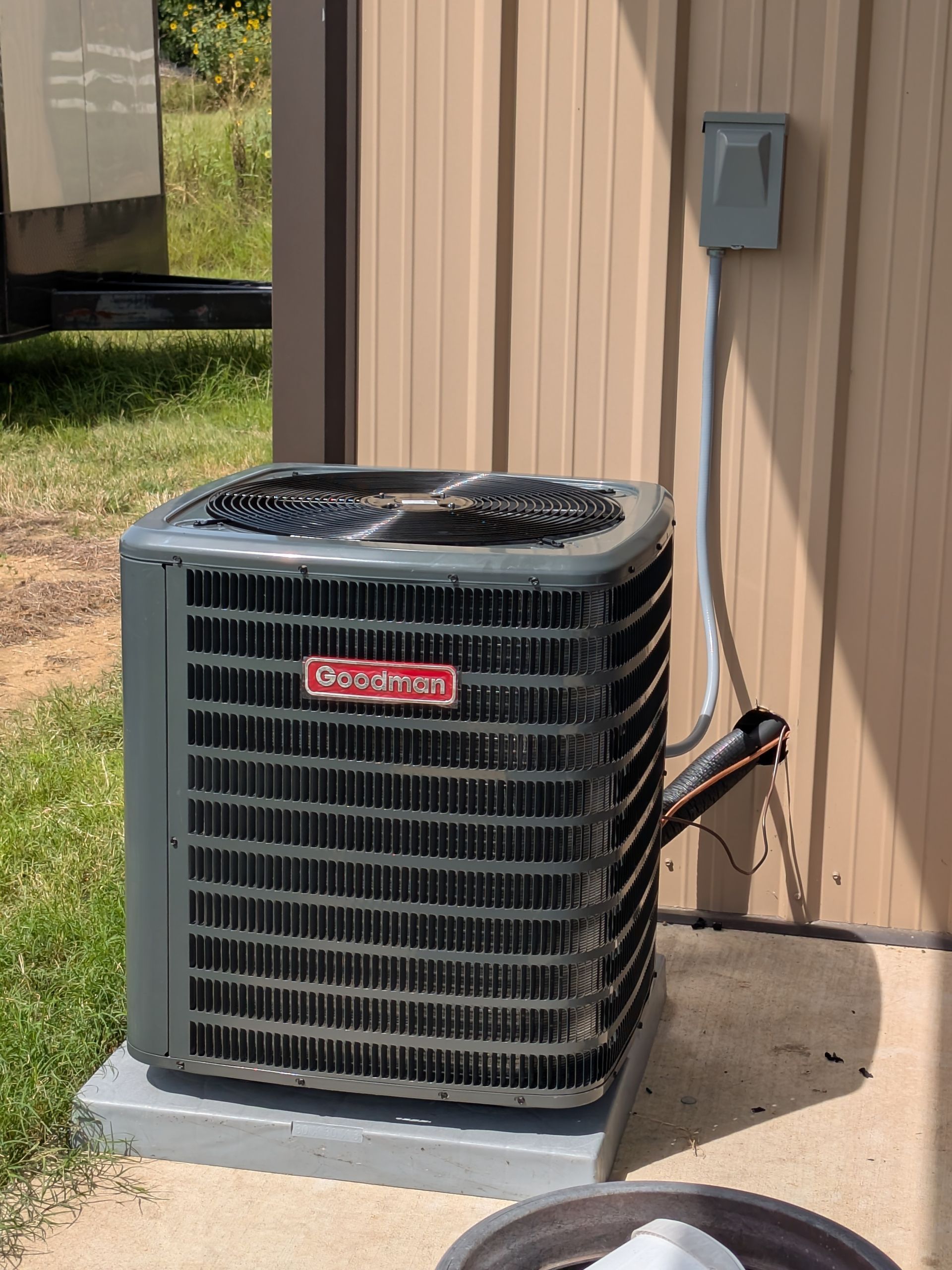 Gray Goodman air conditioning unit outside a building.