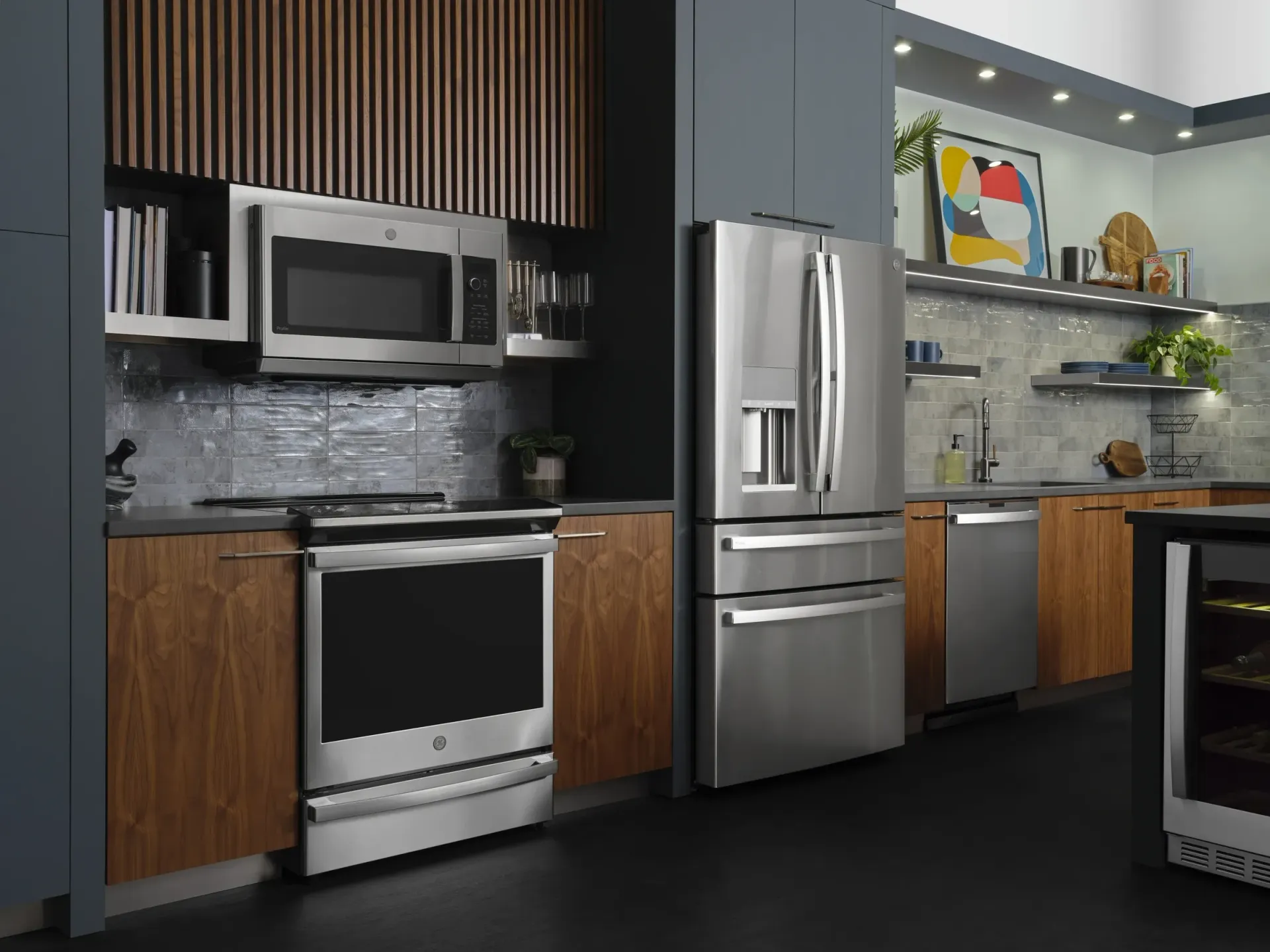 Stainless steel kitchen appliances in a modern kitchen with wooden cabinets and a blue wall.