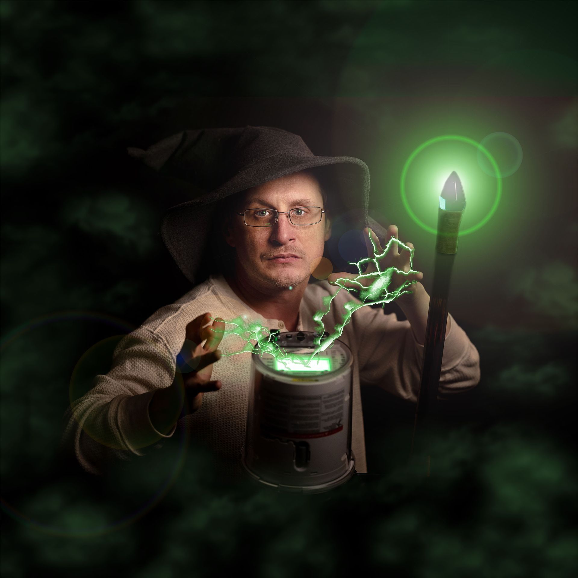 A man in a wizard hat is holding a can and a wand