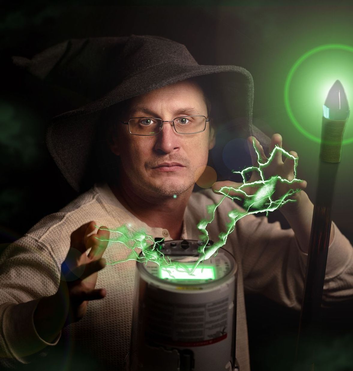 A man in a wizard hat is holding a wand and a can