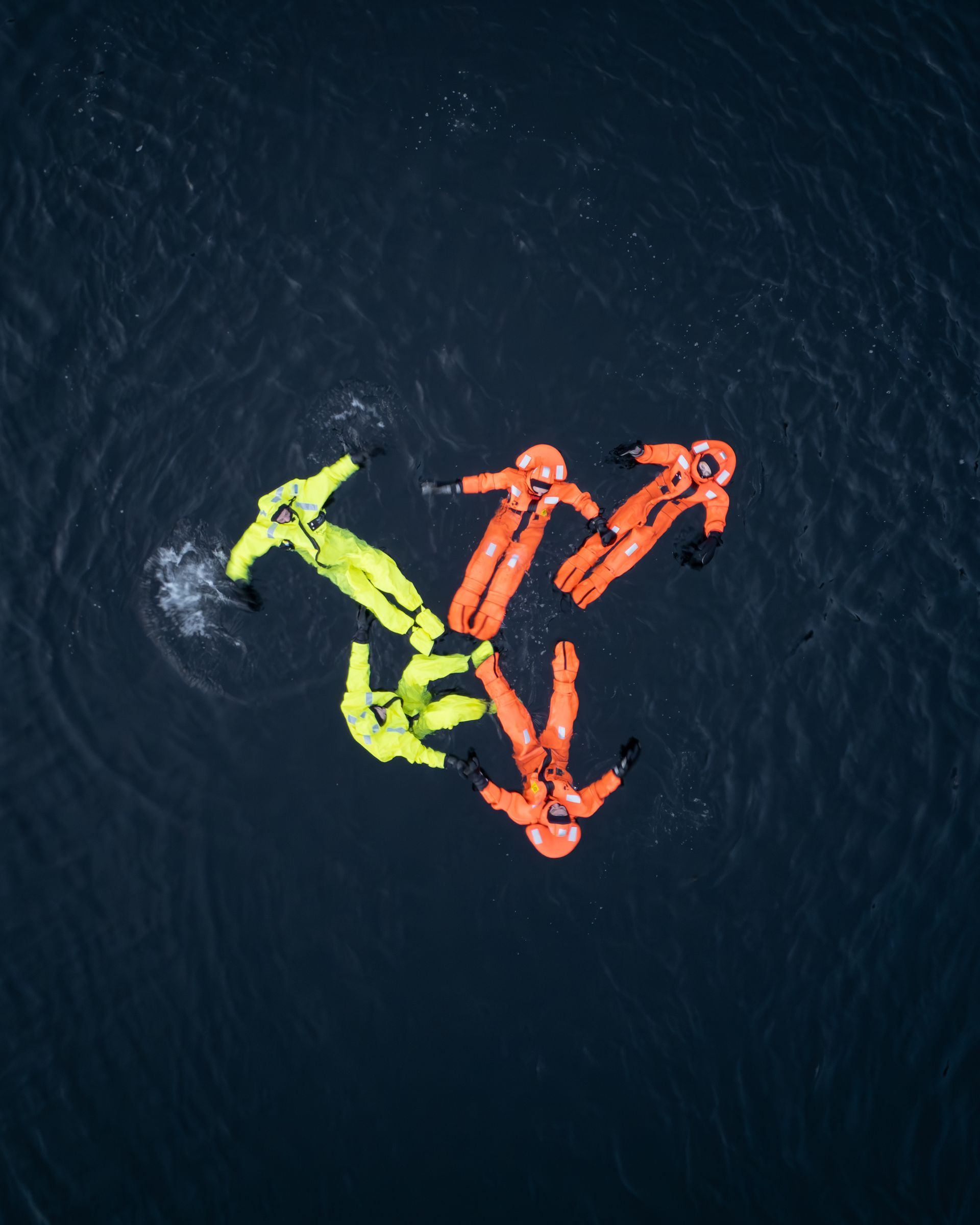 Guest floating on Hardangerfjord in drysuit during winter