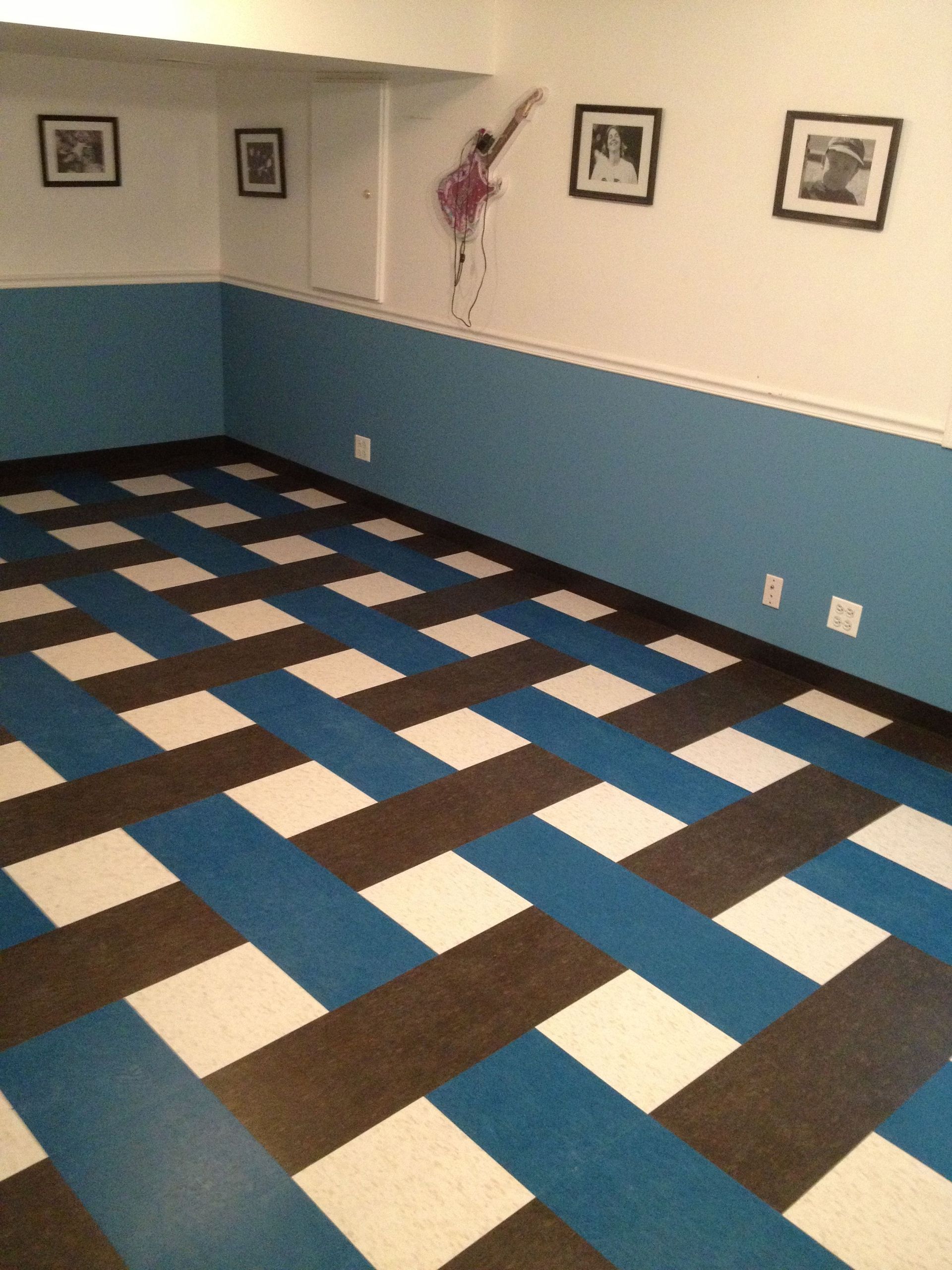 A worker unrolling and installing new carpet indoors.