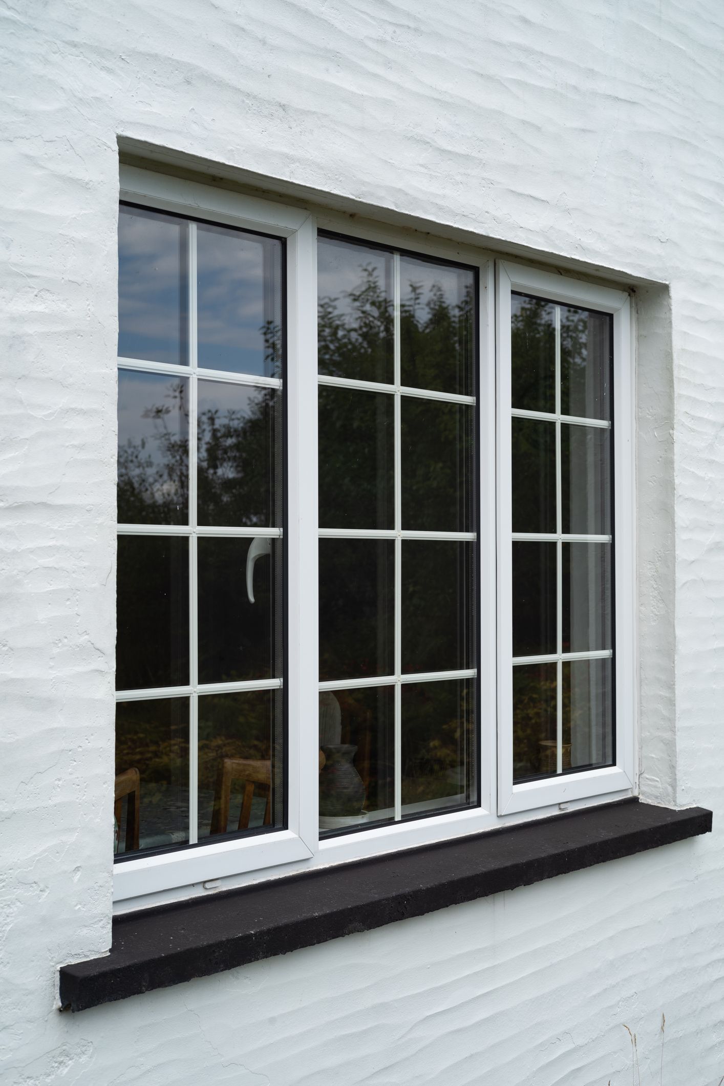 A person is opening a window with a white handle.