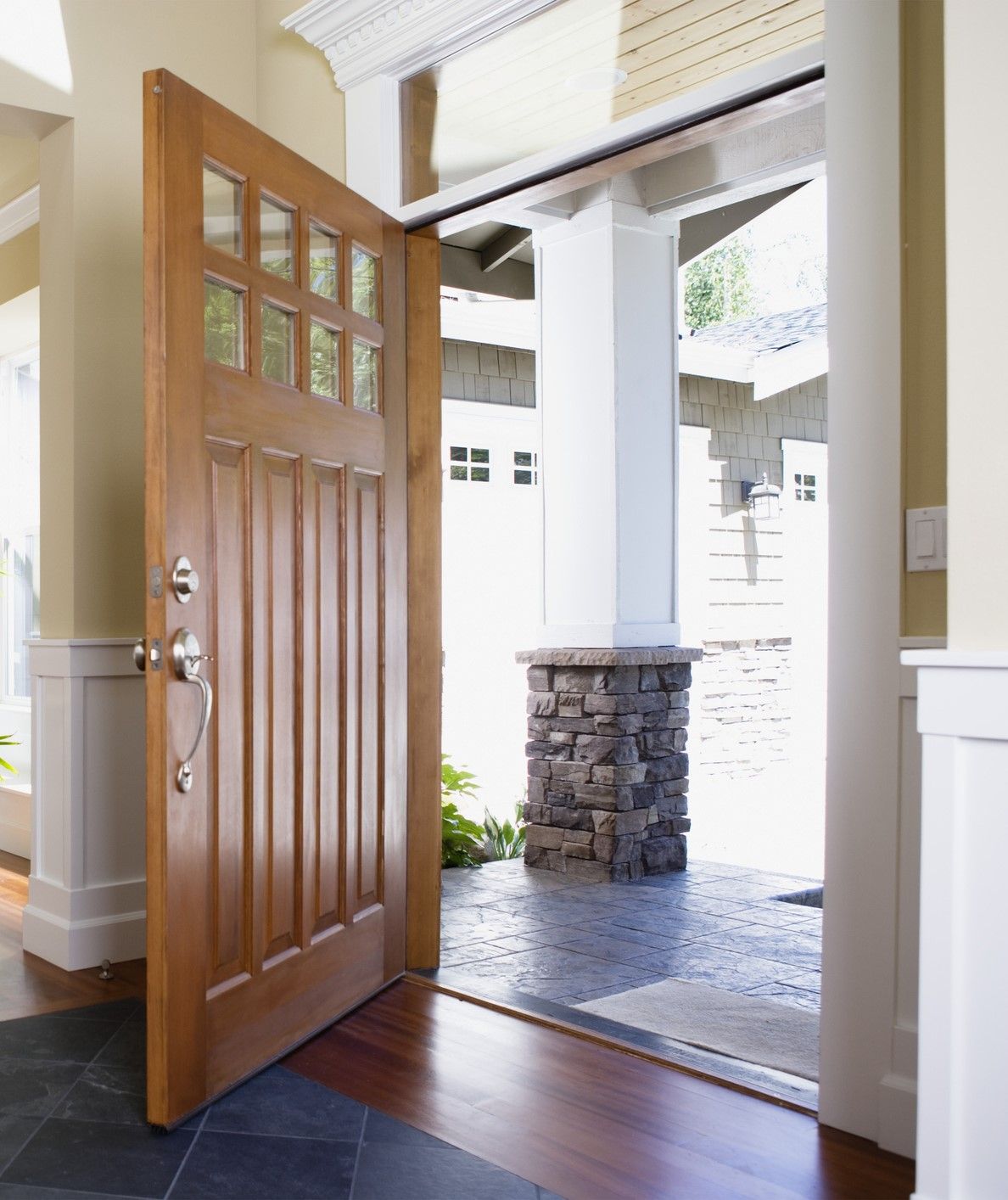 A man is using a drill to fix a door handle.