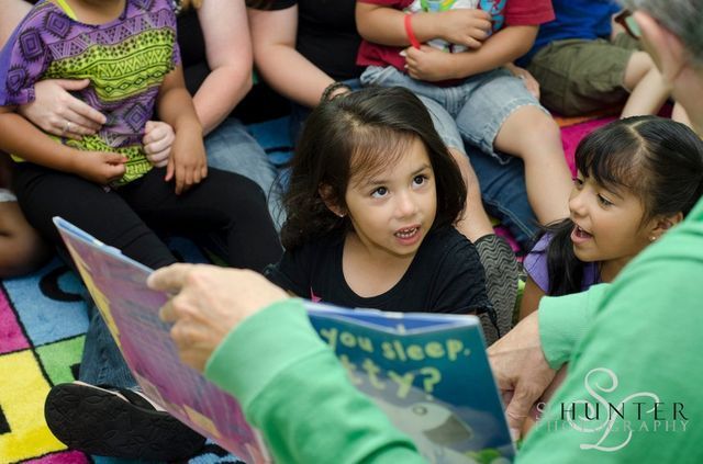 A Man Is Reading a Book to A Group of Children