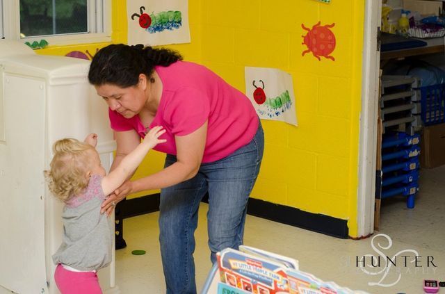 A Woman in A Pink Shirt Is Playing with A Little Girl