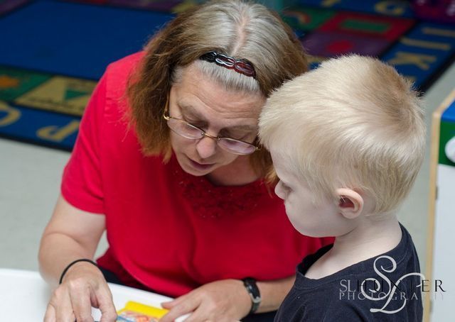 A Woman Is Reading a Book to A Young Boy