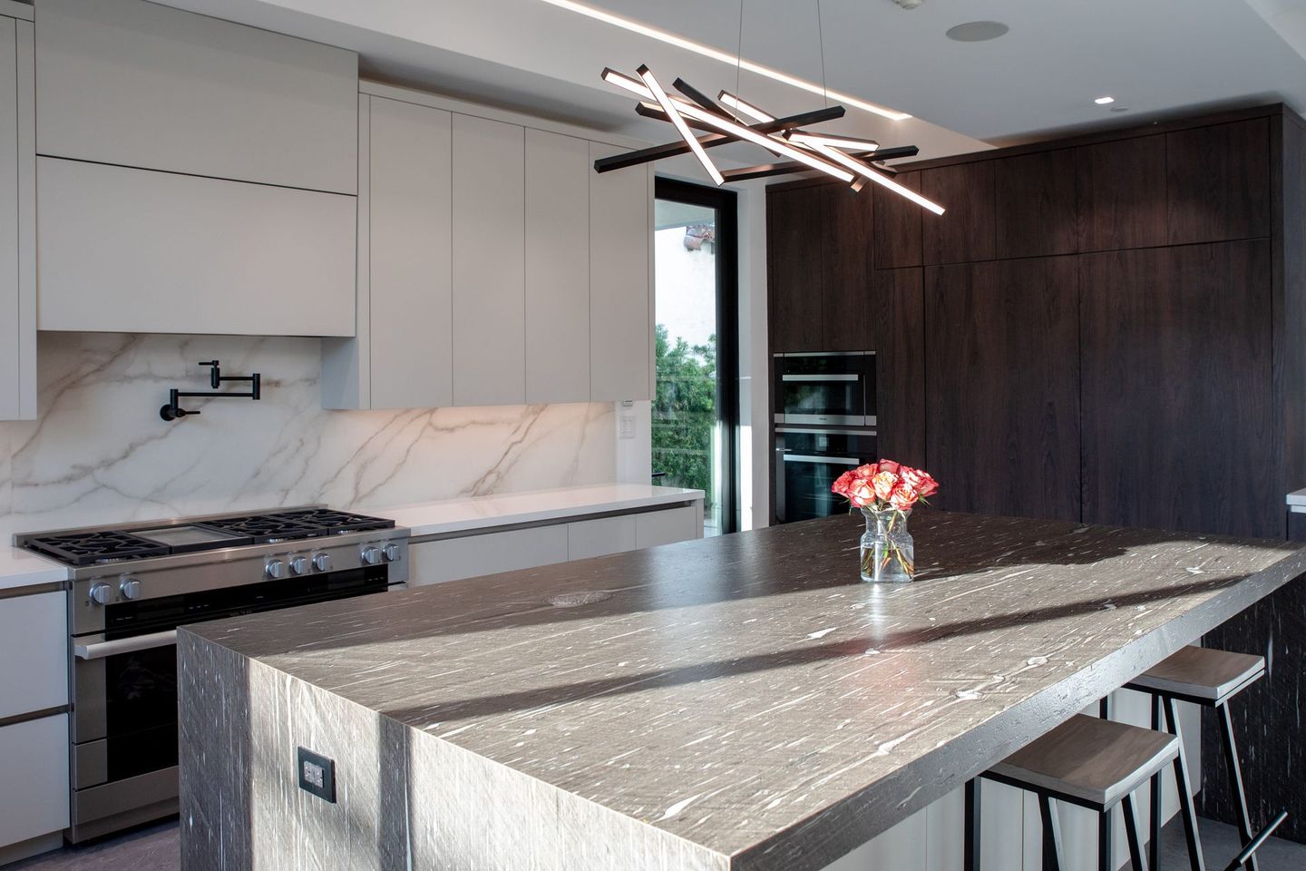 A kitchen with a large island and a stove top oven.