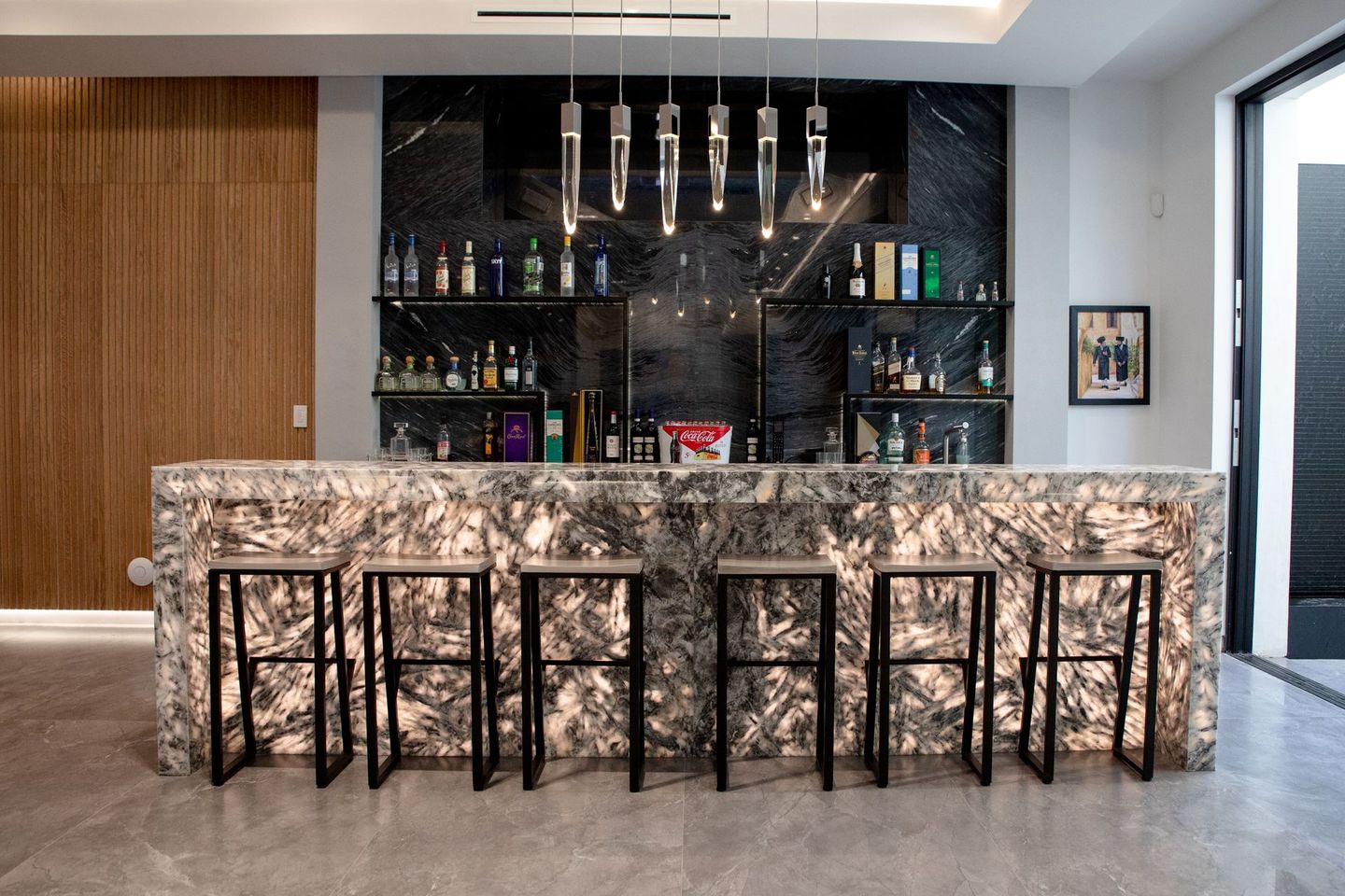 A bar with a marble counter top and stools