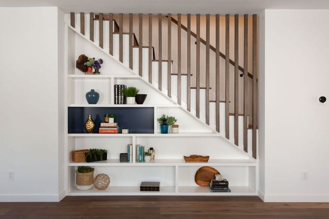 A staircase with a bookshelf underneath it