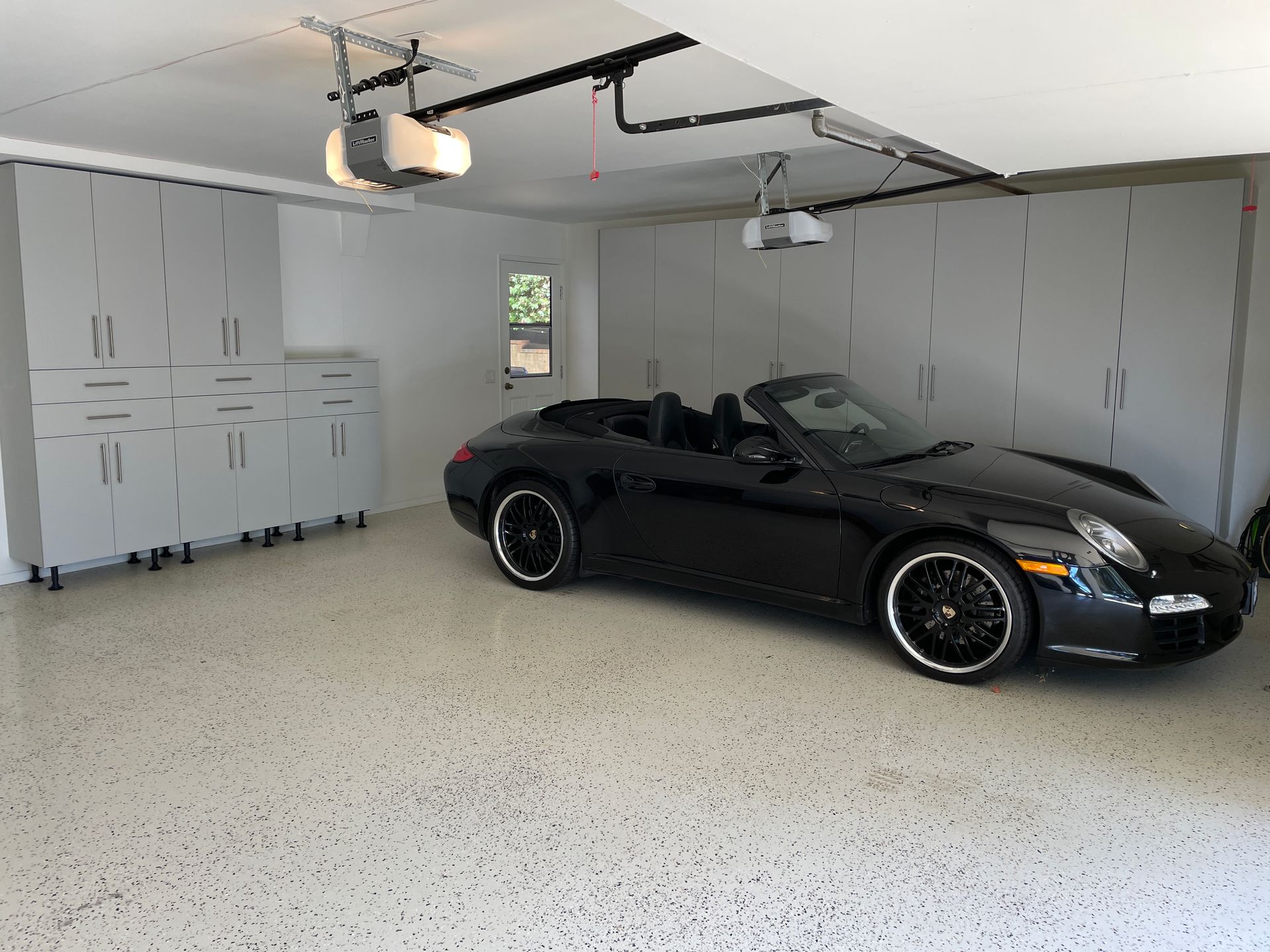 A black sports car is parked in a garage.