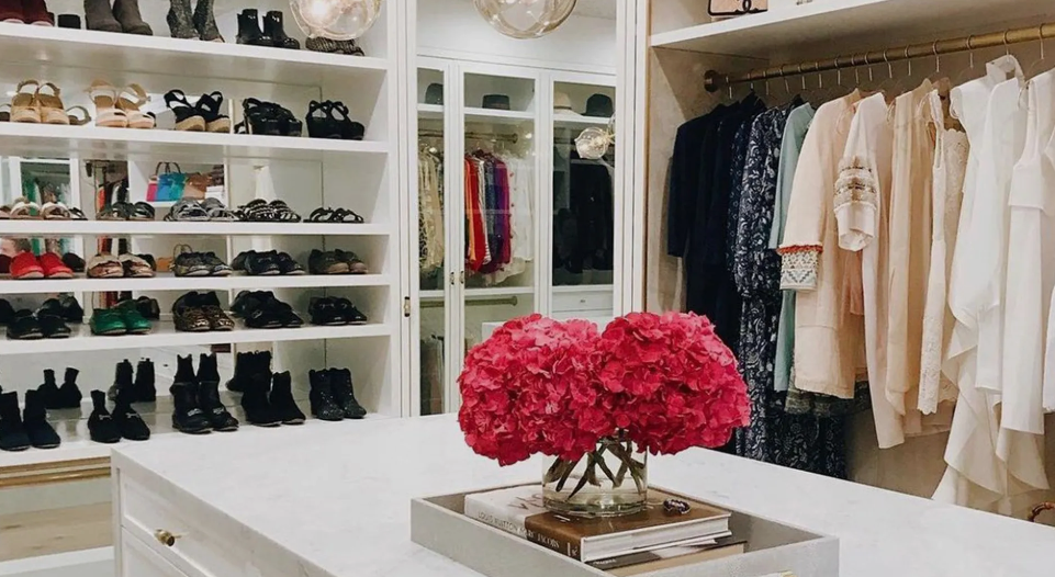 A large walk in closet filled with lots of clothes and shoes.