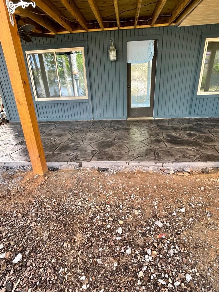 A house with a covered porch and a patio in front of it.