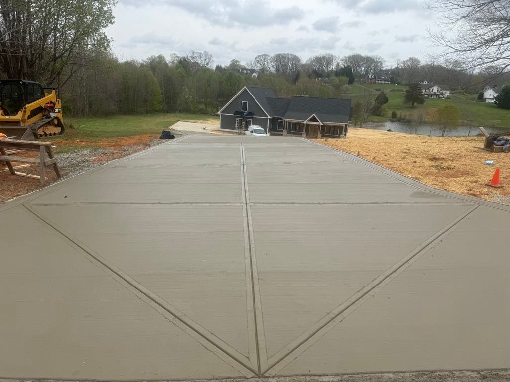 A concrete driveway is being built in front of a house.