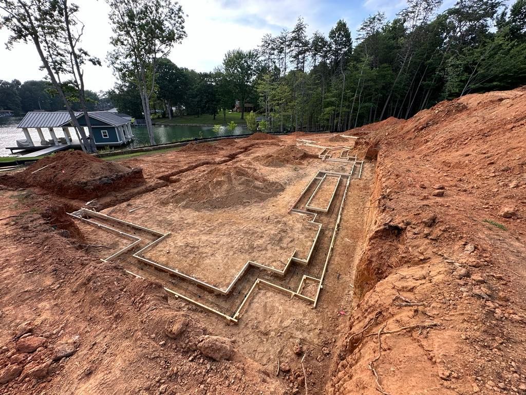 A house is being built on a hill next to a lake.
