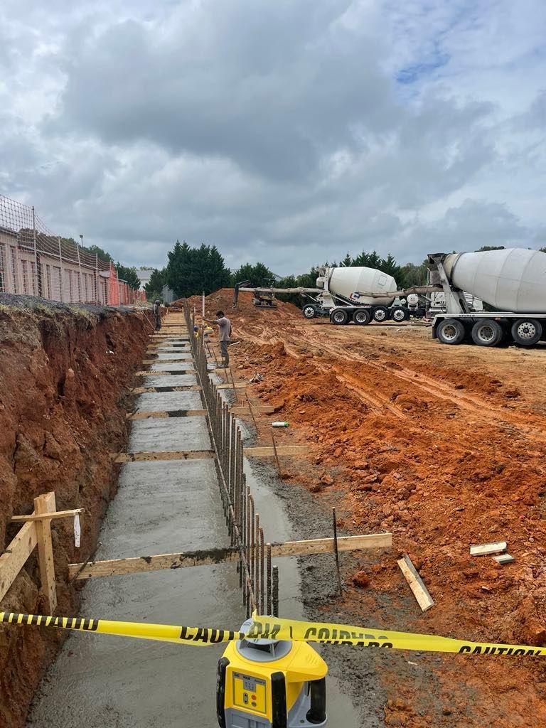 A construction site with a yellow tape that says caution on it.