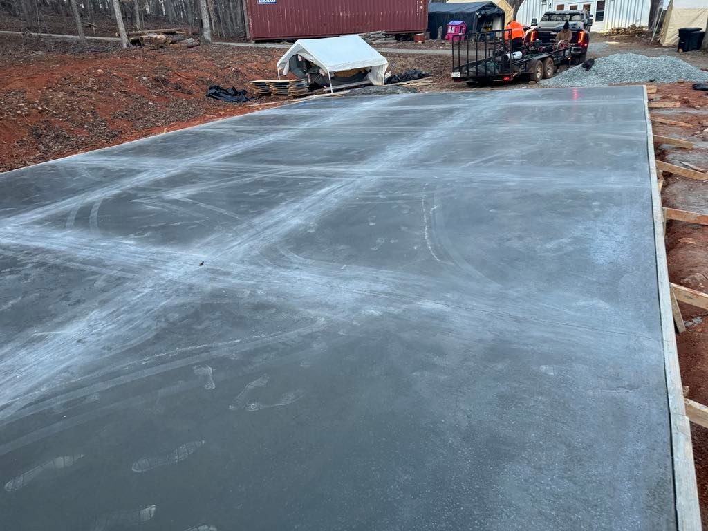A forklift is driving down a concrete driveway.