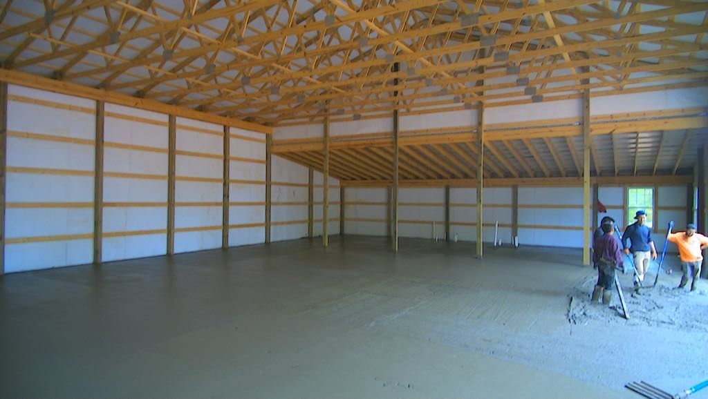 A group of people are walking through a large empty building.