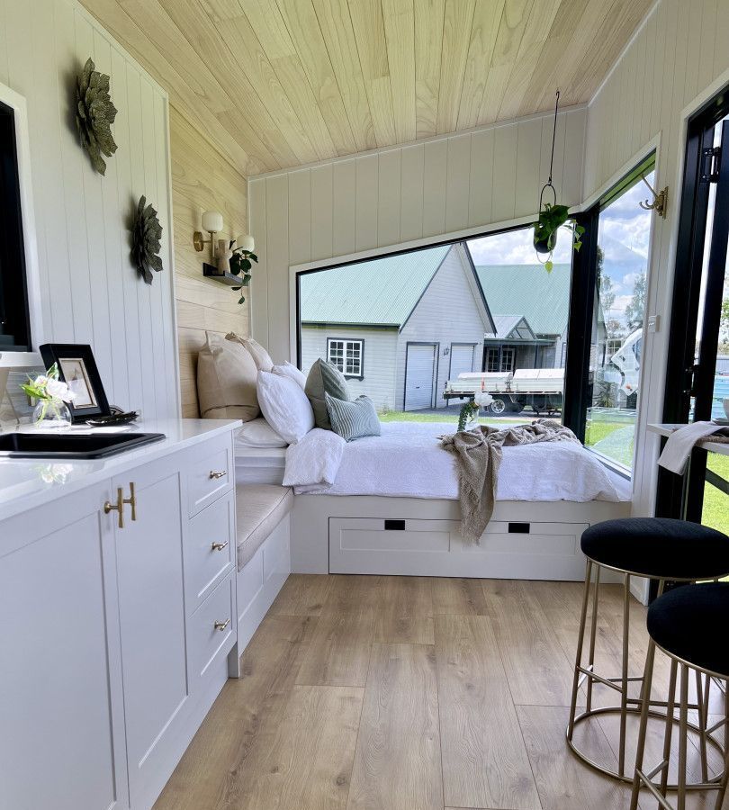 A Bedroom With a Large Bed and a Large Window — Highlands Tiny Homes In Braemar, NSW