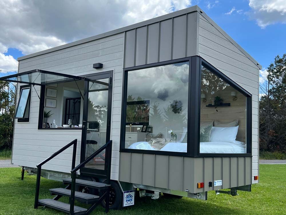 A Tiny House on Wheels is Parked in a Grassy Field — Highlands Tiny Homes In Braemar, NSW