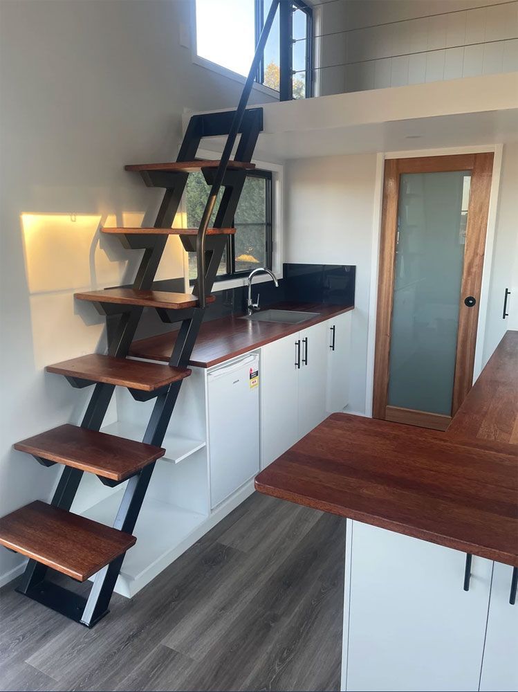 A Kitchen With a Staircase Leading Up to the Second Floor — Highlands Tiny Homes In Braemar, NSW