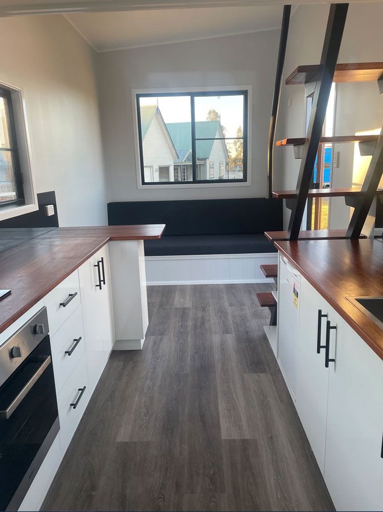A Kitchen With White Cabinets and Wooden Counter Tops — Highlands Tiny Homes In Braemar, NSW