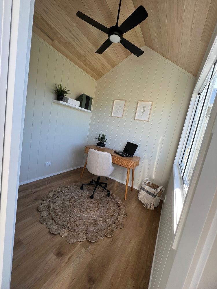 A Small Office With a Desk and Chair and a Ceiling Fan — Highlands Tiny Homes In Braemar, NSW